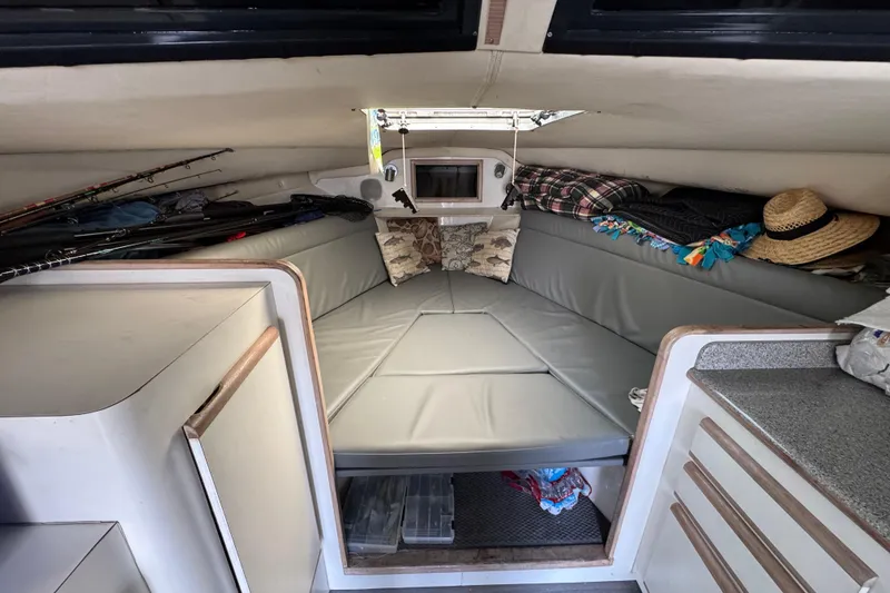 Slide: The Image of 1993 Blackfin Sportfisher cabin interior with fishing rods and cozy seating area. - 39