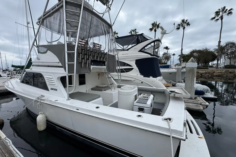 Slide: The Image of 1993 Blackfin Sportfisher boat docked at marina with overcast sky and palm trees. - 4