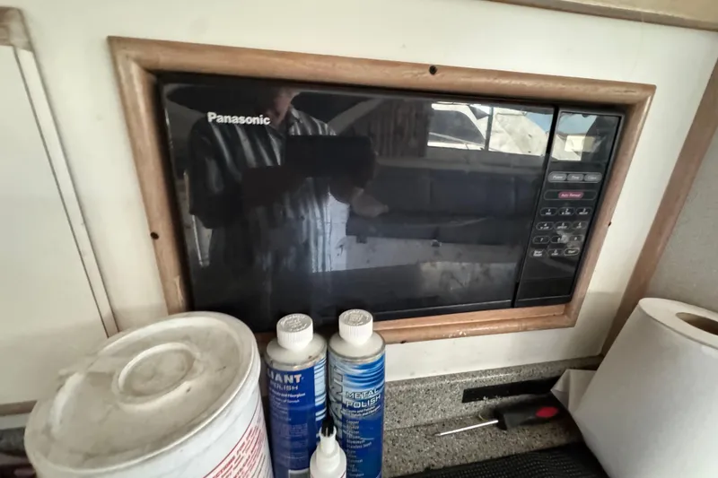 Slide: The Image of Panasonic microwave in 1993 Blackfin Sportfisher kitchen with cleaning supplies. - 42