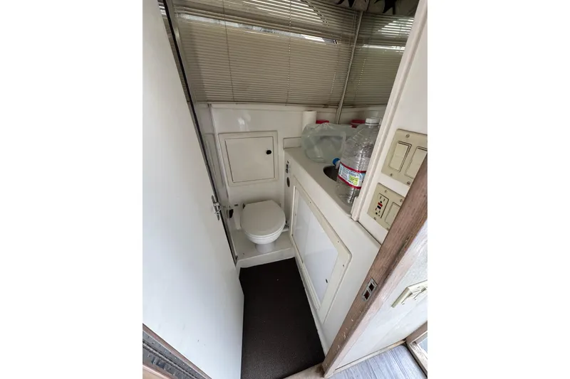 Slide: The Image of 1993 Blackfin Sportfisher boat bathroom with toilet, sink, and storage cabinets. - 48