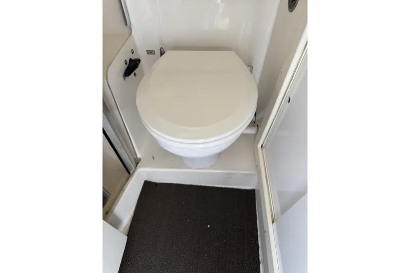 Slide: The Image of 1993 Blackfin Sportfisher boat bathroom with white toilet and compact design. - 49