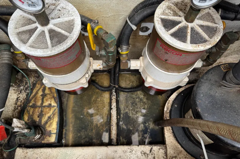 Slide: The Image of Engine room of a 1993 Blackfin Sportfisher with dual fuel filters and hoses. - 58