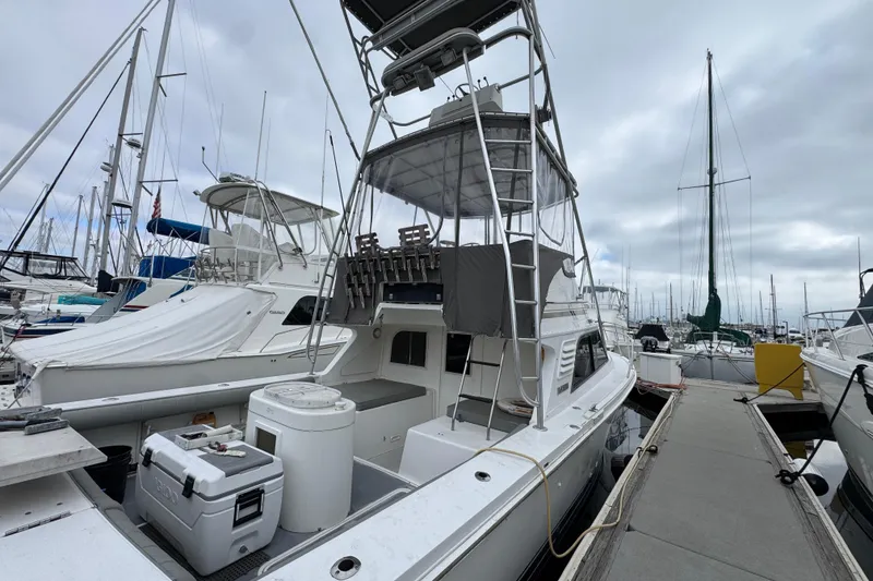 Slide: The Image of 1993 Blackfin Sportfisher boat docked at marina, surrounded by other vessels under cloudy skies. - 9