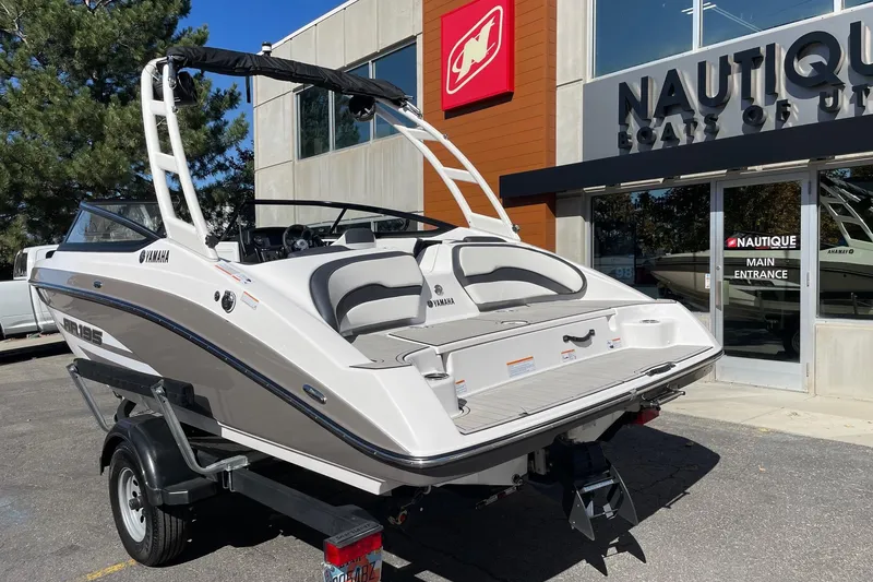 Slide: The Image of 2023 Yamaha Boats AR195 displayed outside Nautique dealership entrance. - 3