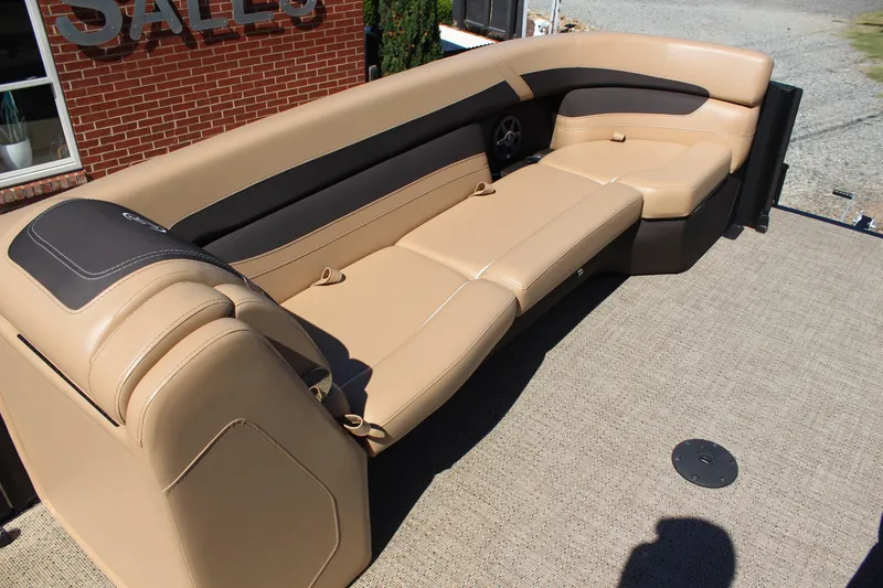 Slide: The Image of 2025 Barletta C24UC boat interior with tan and black seating, outdoor setting. - 10