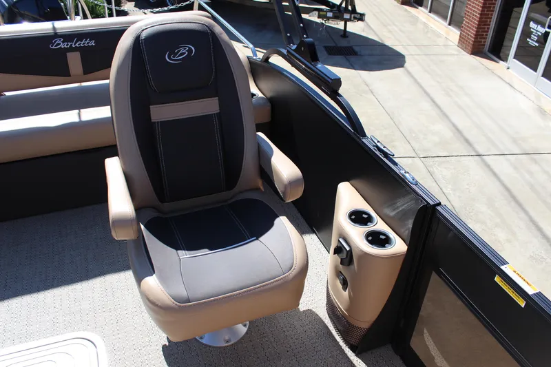 Slide: The Image of 2025 Barletta C24UC boat interior with captain's chair and cup holders. - 9