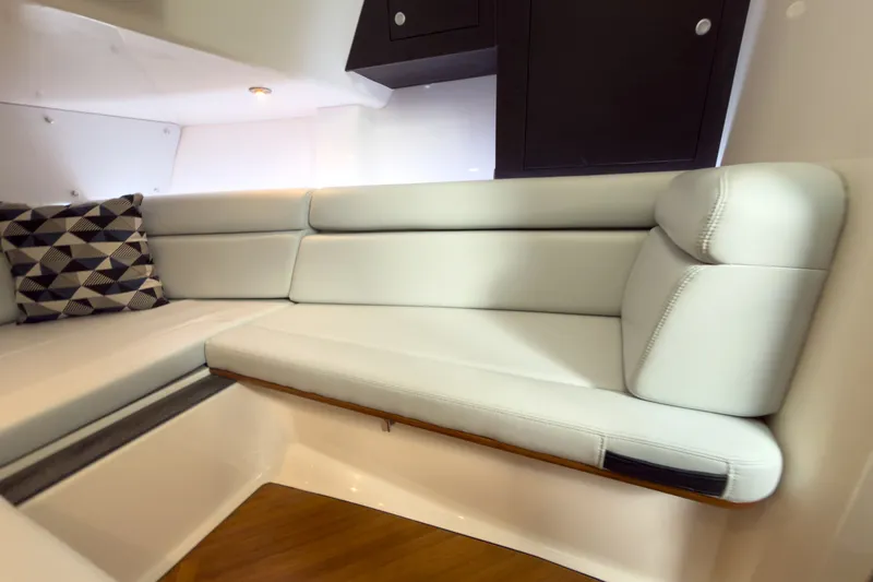 Slide: The Image of The interior cabin of the 2026 Boston Whaler 350 Realm features an elegant, cushioned seating area. - 18