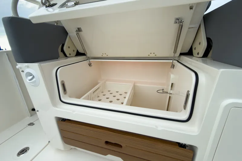 Slide: The Image of The 2026 Boston Whaler 350 Realm features an open storage compartment with dividers and wood accents. - 8
