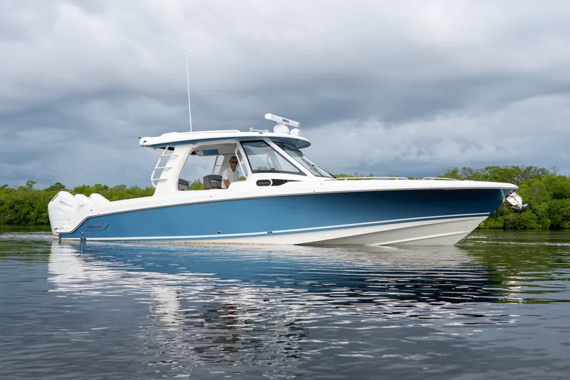 Slide: The Image of A sleek blue and white motorboat on calm water, surrounded by green vegetation. - 41