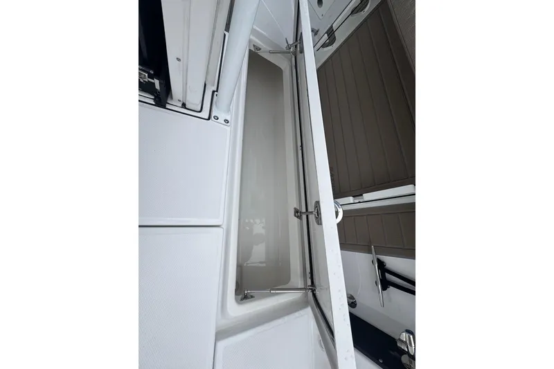 Slide: The Image of 2025 Blackfin 272CC boat storage compartment with open hatch, showcasing interior details. - 21