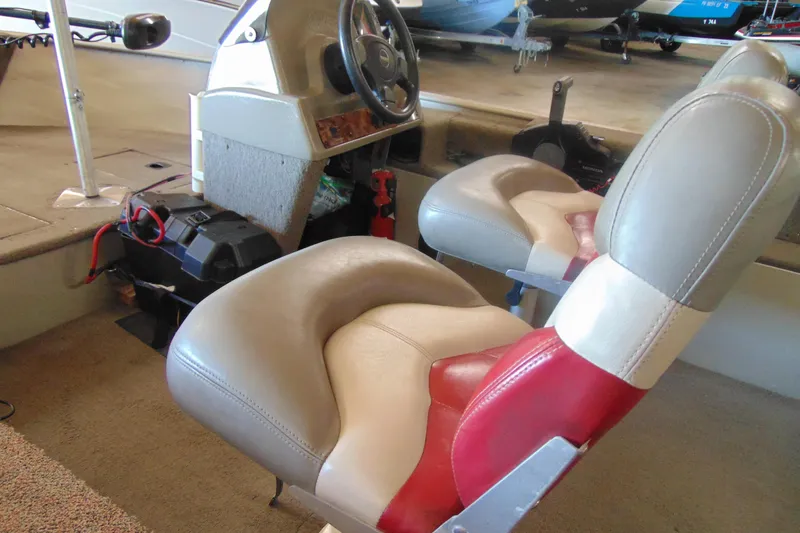 Slide: The Image of 2002 Tracker Super Guide V-15 boat interior with steering wheel and cushioned seats. - 11