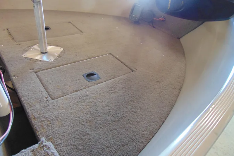 Slide: The Image of 2002 Tracker Super Guide V-15 boat interior with carpeted deck and storage compartments. - 14