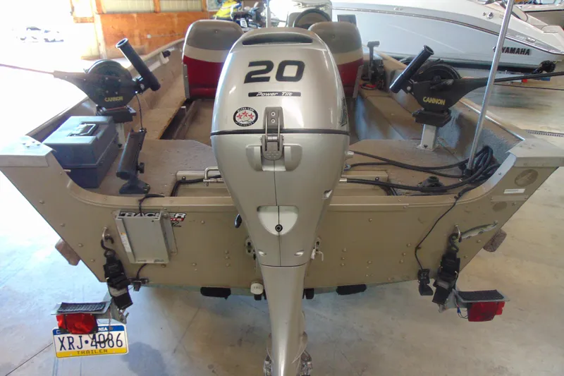 Slide: The Image of 2002 Tracker Super Guide V-15 boat with 20HP outboard motor in a garage. - 4