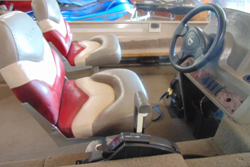 Slide: The Image of 2002 Tracker Super Guide V-15 boat interior with steering wheel and red-white seats. - 6