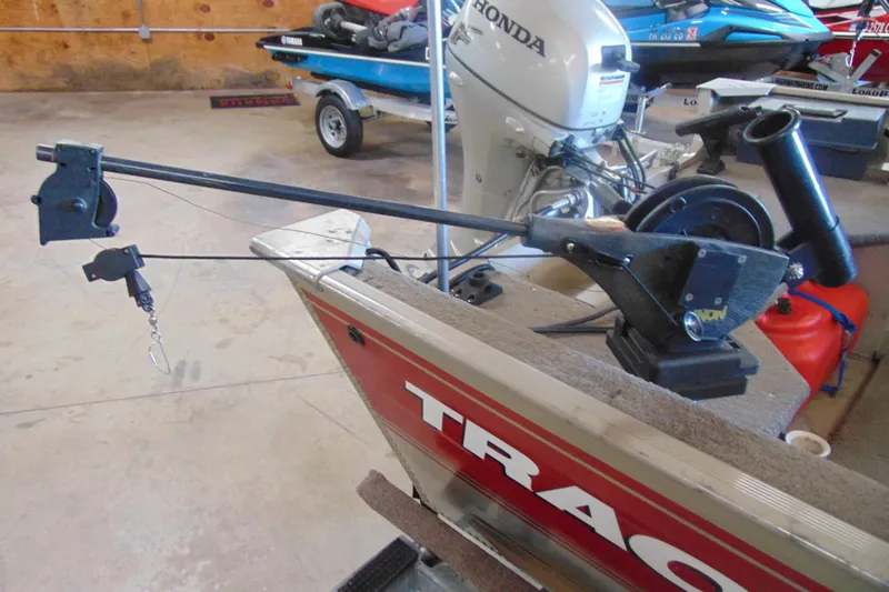 Slide: The Image of 2002 Tracker Super Guide V-15 boat with fishing equipment and Honda outboard motor in a garage. - 9