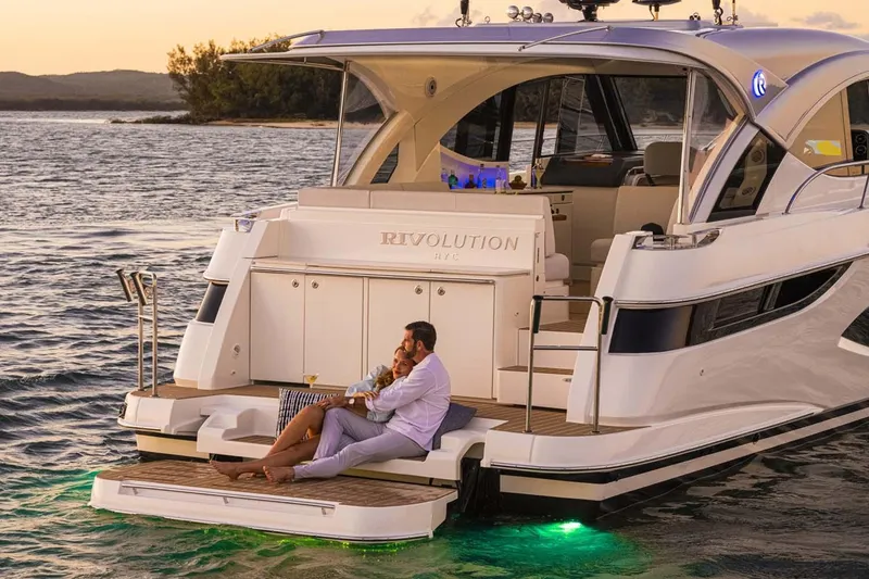 Slide: The Image of Manufacturer Provided Image: Couple relaxing on a 2026 Riviera 4300 Sport Express yacht at sunset. - 2