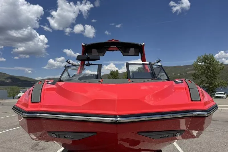 Slide: The Image of 2025 Supra SL 575 boat, vibrant red, parked under a clear blue sky. - 2