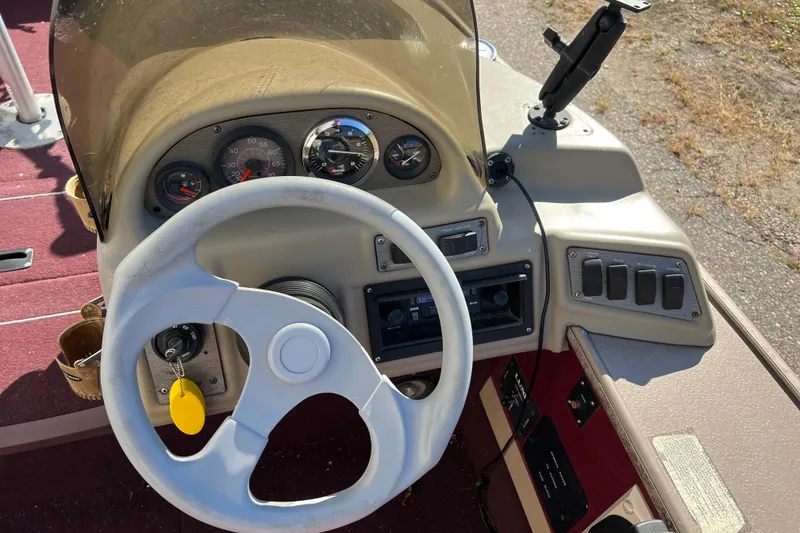 Slide: The Image of 1996 Lund 1800 Pro-V SE boat dashboard with steering wheel and control panel. - 5