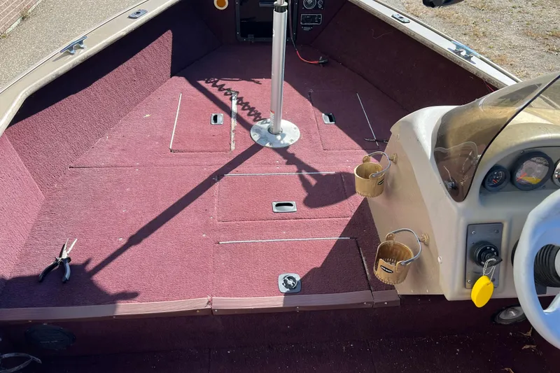 Slide: The Image of 1996 Lund 1800 Pro-V SE boat interior with maroon carpet and steering console. - 6