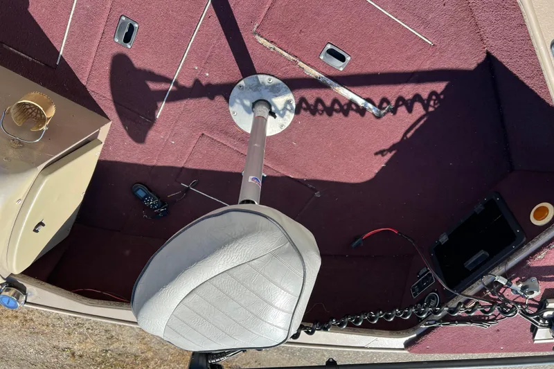 Slide: The Image of 1996 Lund 1800 Pro-V SE boat interior with maroon carpet and swivel seat. - 7