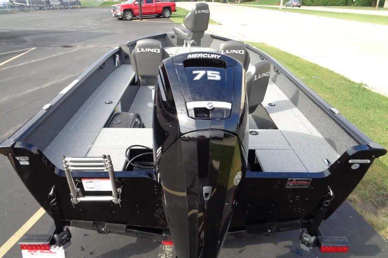 Slide: The Image of 2026 Lund 1800 Explorer Tiller boat with Mercury 75 engine, parked on pavement. - 10