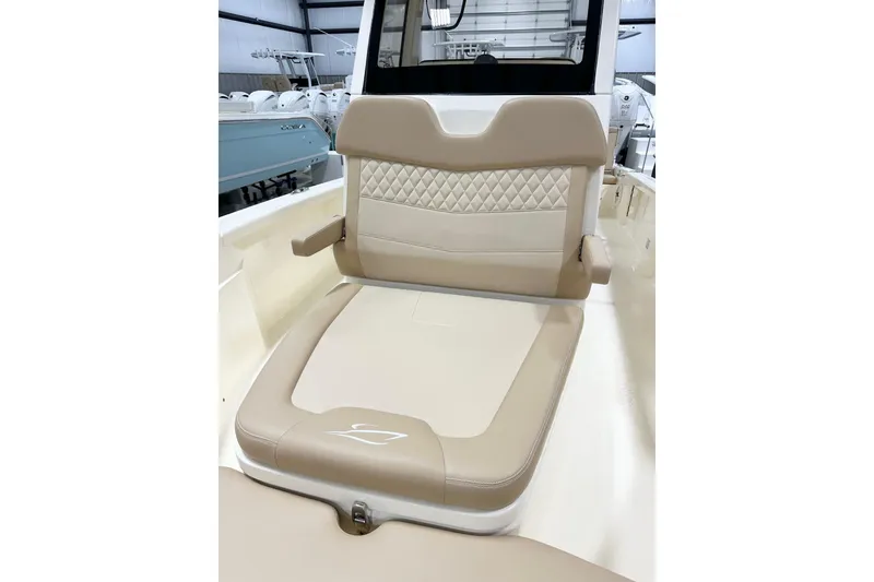 Slide: The Image of 2026 Scout 261 XSS boat seat with beige and white upholstery in a showroom. - 12