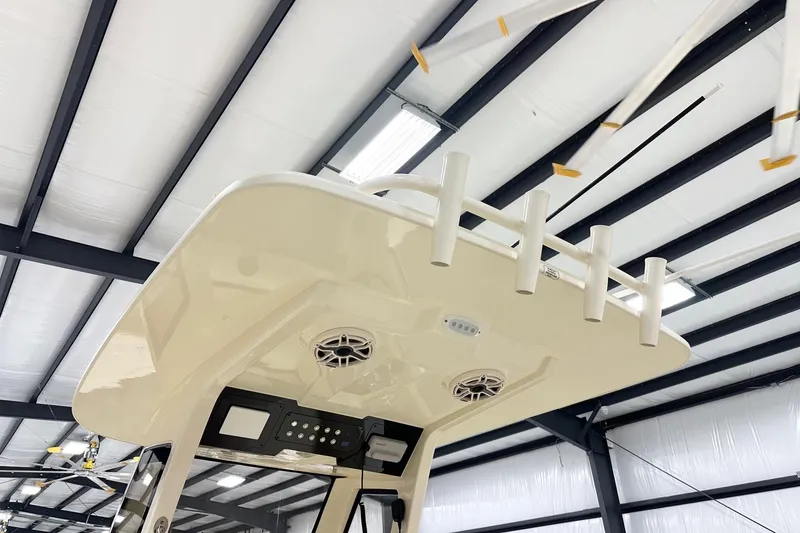 Slide: The Image of 2026 Scout 261 XSS boat interior with rod holders and speakers in a warehouse. - 7