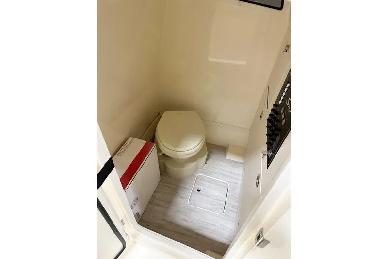 Slide: The Image of 2026 Scout 261 XSS boat interior bathroom with toilet and control panel. - 8