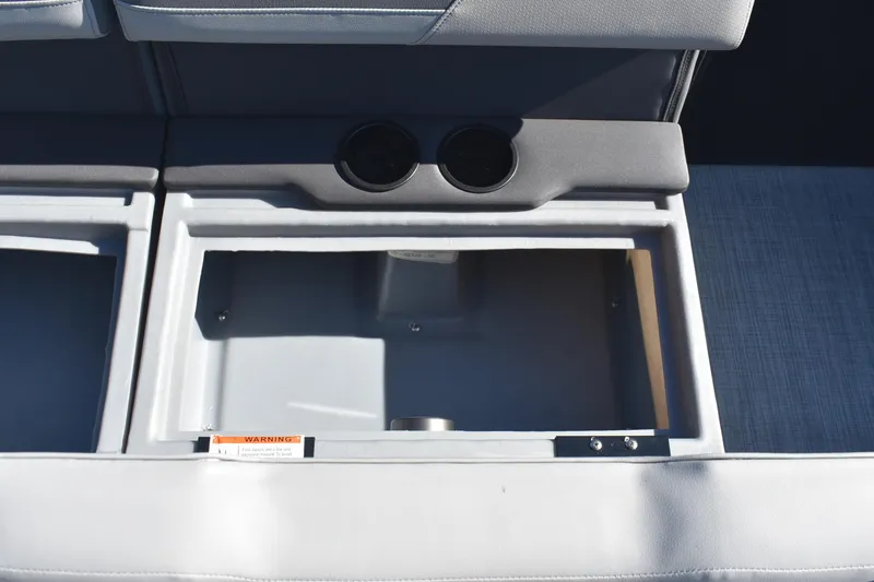 Slide: The Image of 2026 Lowe LS 170 boat storage compartment with cup holders and warning label. - 16
