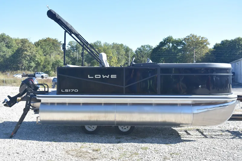 Slide: The Image of 2026 Lowe LS 170 pontoon boat on trailer, parked outdoors. - 4