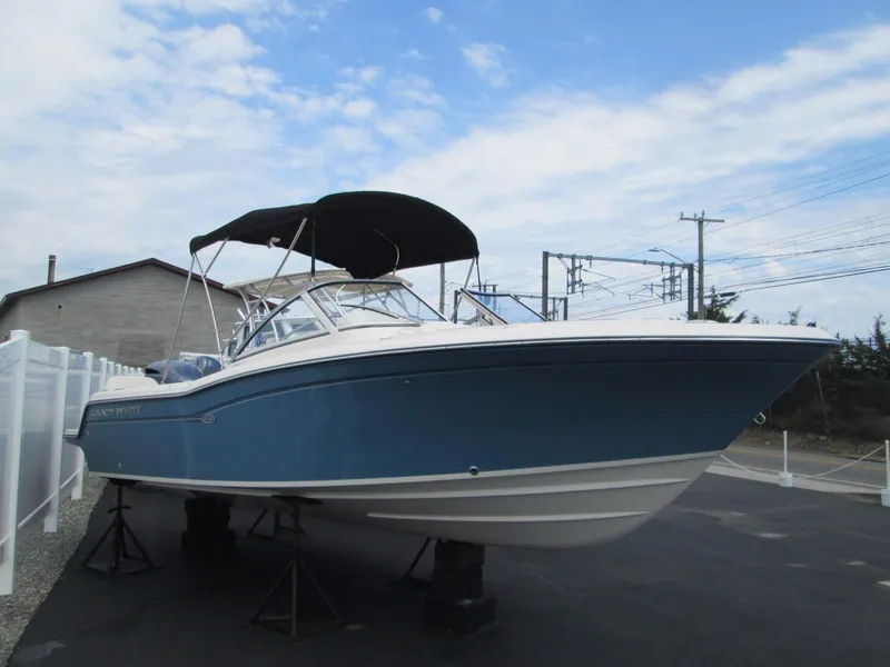 Slide: The Image of 2018 Grady-White Freedom 215 boat with blue hull and black canopy. - 2