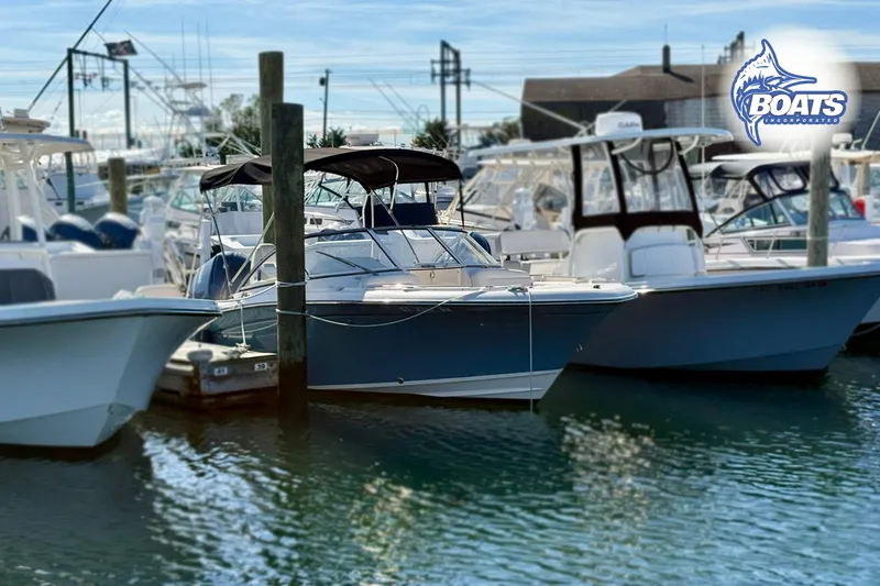 Slide: The Image of 2018 Grady-White Freedom 215 boat docked at marina, surrounded by other vessels. - 3