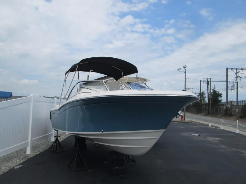 Slide: The Image of 2018 Grady-White Freedom 215 boat with blue hull, docked under a cloudy sky. - 4