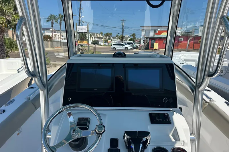 Slide: The Image of 2021 Sportsman Open 282 Center Console boat dashboard with dual screens and steering wheel. - 10