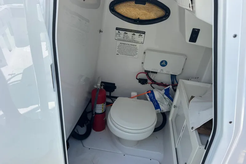 Slide: The Image of 2021 Sportsman Open 282 Center Console boat interior with toilet and fire extinguisher. - 5