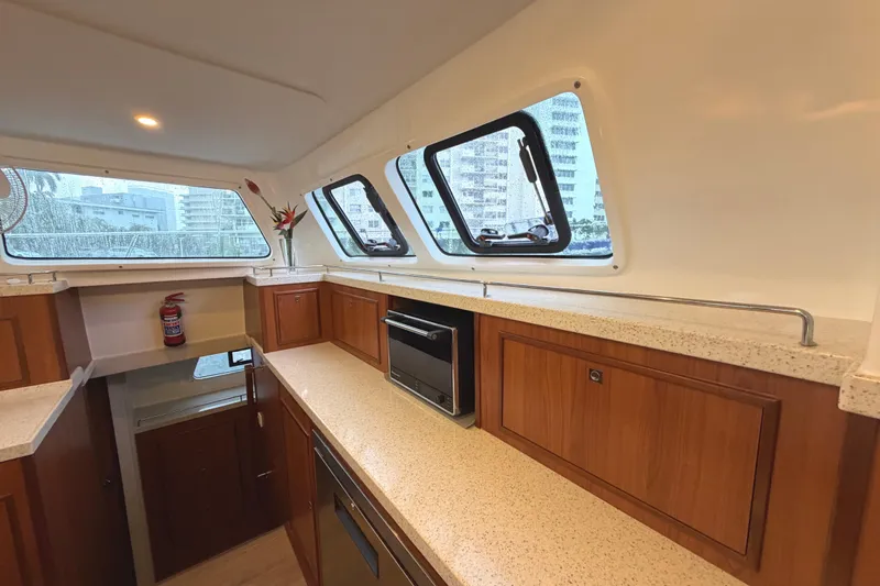 Slide: The Image of Interior of 2023 Royal Cape Catamarans Majestic 530, featuring modern kitchen with wood cabinetry. - 113