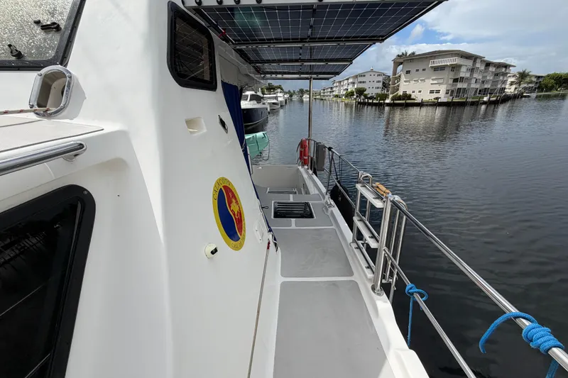 Slide: The Image of 2023 Royal Cape Catamarans Majestic 530 docked, featuring solar panels and waterfront view. - 15