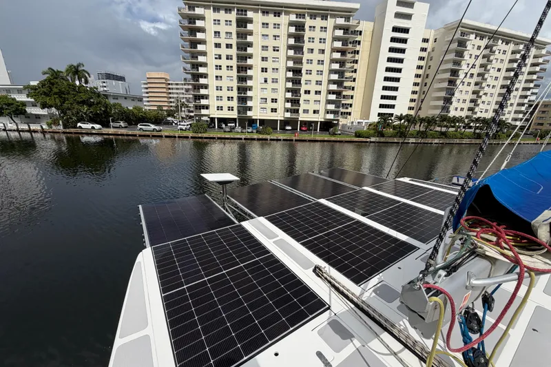 Slide: The Image of 2023 Royal Cape Catamarans Majestic 530 with solar panels docked near waterfront buildings. - 21