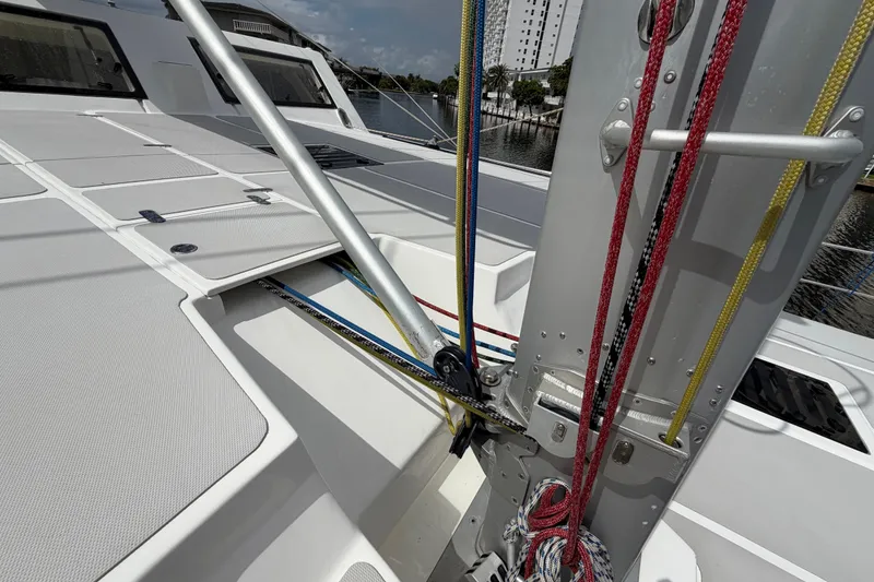 Slide: The Image of 2023 Royal Cape Catamarans Majestic 530 deck with rigging and hatches, docked by water. - 26