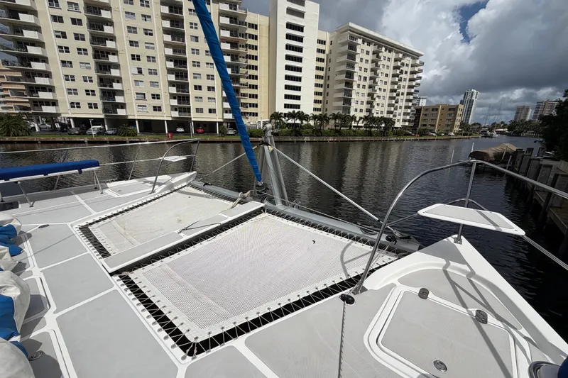 Slide: The Image of 2023 Royal Cape Catamarans Majestic 530 docked near waterfront buildings under cloudy sky. - 30