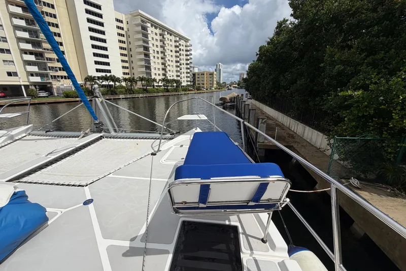 Slide: The Image of 2023 Royal Cape Catamarans Majestic 530 docked near waterfront buildings and lush greenery. - 31