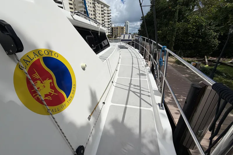 Slide: The Image of 2023 Royal Cape Catamarans Majestic 530 docked, featuring "Calacoto" emblem on the side. - 34