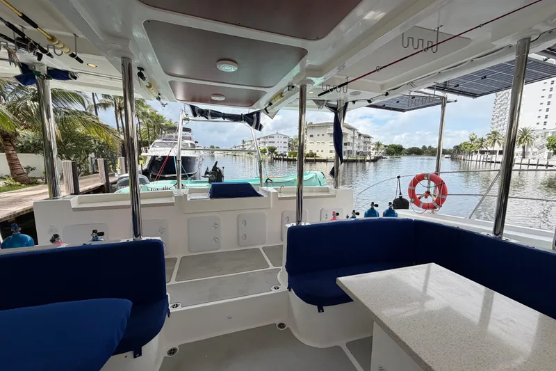 Slide: The Image of Interior view of 2023 Royal Cape Catamarans Majestic 530, featuring spacious seating and waterfront backdrop. - 46