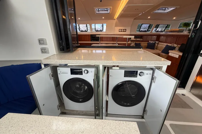 Slide: The Image of Laundry area on 2023 Royal Cape Catamarans Majestic 530, featuring dual washing machines. - 58