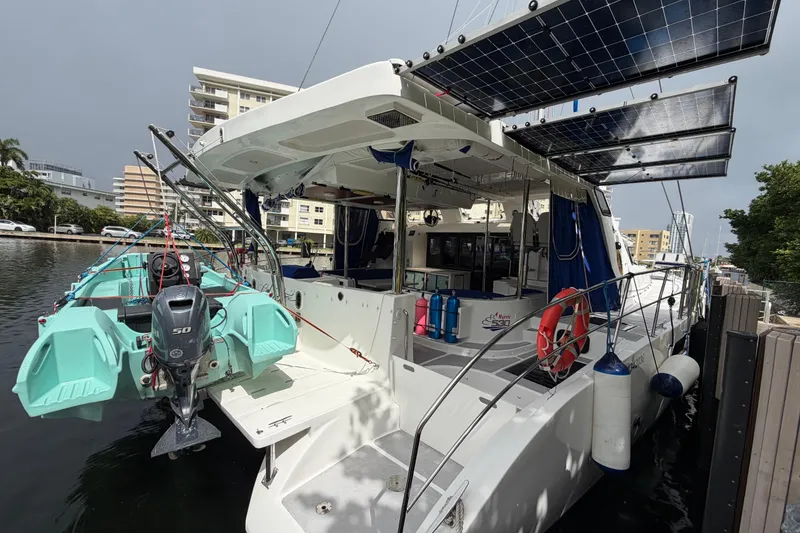 Slide: The Image of 2023 Royal Cape Catamarans Majestic 530 docked, featuring solar panels and an outboard motor. - 6