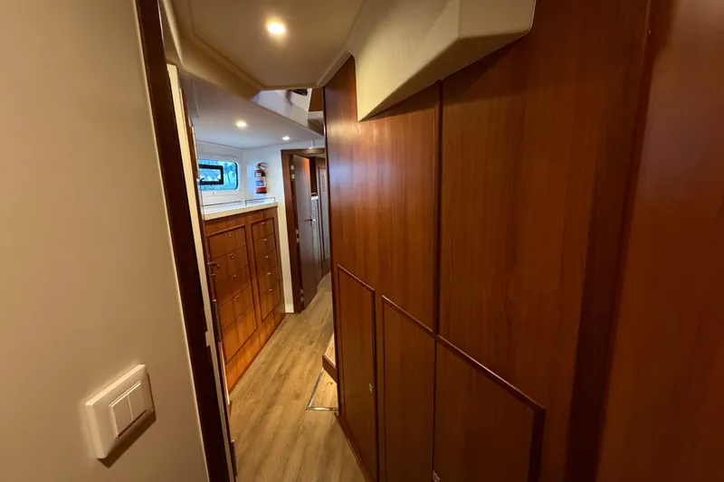 Slide: The Image of Interior hallway of 2023 Royal Cape Catamarans Majestic 530, featuring wooden cabinetry and modern lighting. - 63