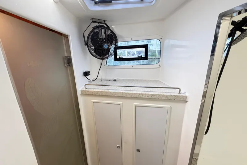 Slide: The Image of Interior of 2023 Royal Cape Catamarans Majestic 530, featuring a fan and storage cabinets. - 71