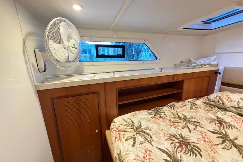 Slide: The Image of Interior cabin of 2023 Royal Cape Catamarans Majestic 530 with bed, fan, and window. - 85