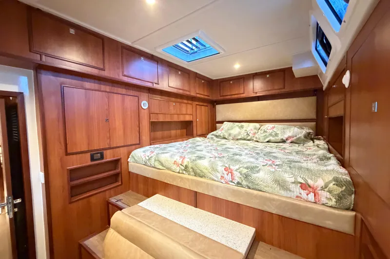 Slide: The Image of Luxurious cabin interior of 2023 Royal Cape Catamarans Majestic 530 with wood paneling and floral bedding. - 96