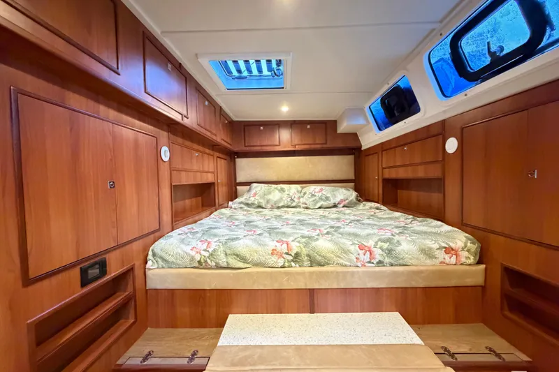 Slide: The Image of Luxurious cabin interior of 2023 Royal Cape Catamarans Majestic 530 with wood paneling and floral bedding. - 98